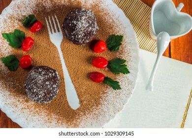 chocolate cake with coconut chips on a white dish with kumquat and mint