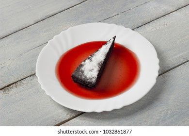 Chocolate decadence pie with raspberry jam on a wooden background