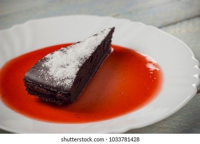 Chocolate decadence pie with strawberry jam on a wooden background