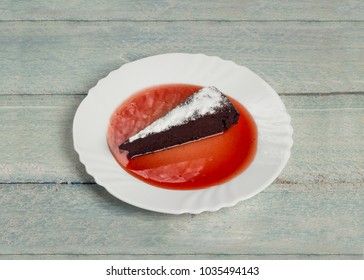 Chocolate decadence pie with strawberry jam on a wooden background