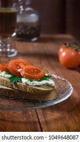 Irish breakfast sandwich with curd cheese, herbs and tomatoes on a background with coffee