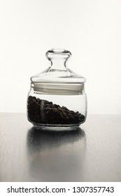 Coffee beans in a glass jar isolated on a back white background