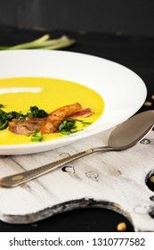 Pea soup with pieces of bacon, parsley and onion in a bowl on a dark background. Pea cream soup.