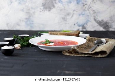 Traditional Ukrainian Russian borsch with sour cream and white beans on a dark background. Red vegetable beetroot soup.