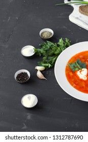 Traditional Ukrainian Russian borsch with sour cream and white beans on a dark background. Red vegetable beetroot soup.