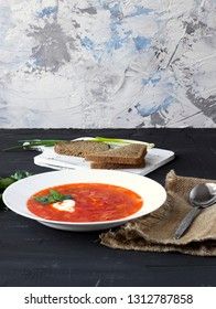 Traditional Ukrainian Russian borsch with sour cream and white beans on a dark background. Red vegetable beetroot soup.