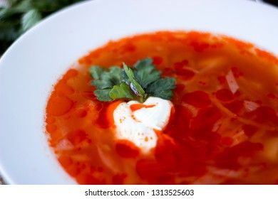 Traditional Ukrainian Russian borsch with sour cream and white beans on a dark background near. Red vegetable beetroot soup.