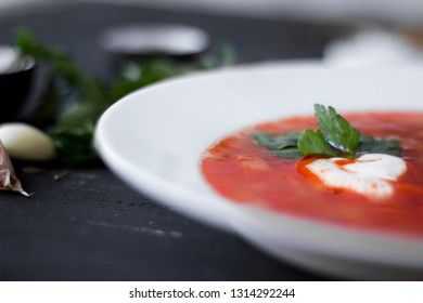 Traditional Ukrainian Russian borsch with sour cream and white beans on a dark background. Red vegetable beetroot soup.