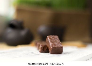 chocolate candies on clay teapot background