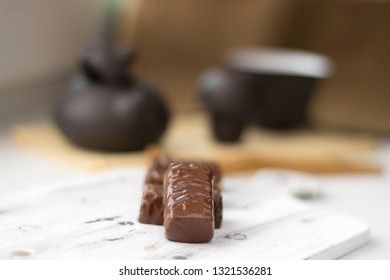 chocolate candies on clay teapot background