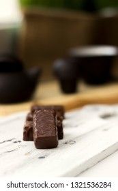 chocolate candies on clay teapot background