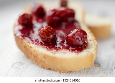 Bread with homemade cherry jam on a light background, closeup