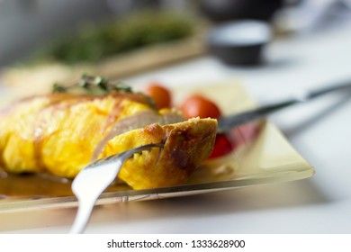 Baked chicken breast with onions and tomatoes on a white plate. Healthy food.