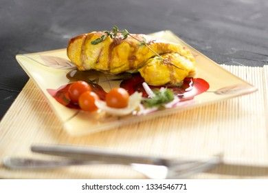 Baked chicken breast with onions and tomatoes on a white plate. Healthy food.