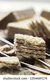 Sweet russian artek waffles on wooden background, with a pot of milk, macro. Traditional sweets and dessert.