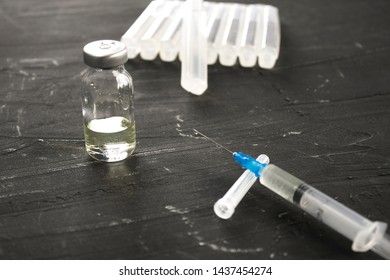 Medical ampoules with vaccine and syringe on gray background. Medical ampoules with pure vaccine and syringe on gray background