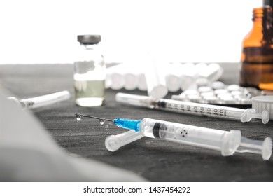 Medical ampoules with vaccine and syringe on gray, white background. Medical ampoules with pure vaccine and syringe on gray, white background