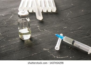 Medical ampoules with vaccine and syringe on gray background. Medical ampoules with pure vaccine and syringe on gray background