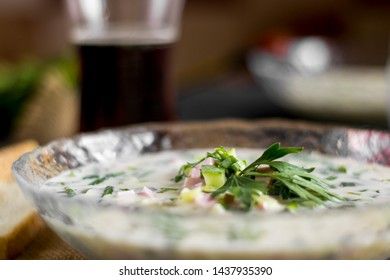 Cold Soup Okroshka. With sausage, vegetables and kvass serving size in bowl and raw ingredients on wooden table