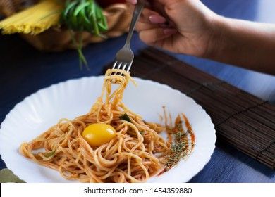 Delicious pasta with egg yolk, on wooden table.