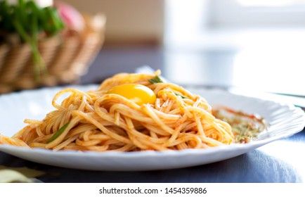 Delicious pasta with egg yolk, on wooden table.