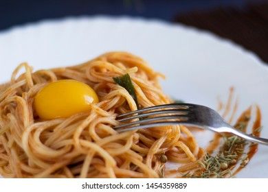Delicious pasta with egg yolk, on wooden table.