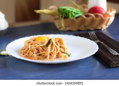 Delicious pasta with egg yolk, on wooden table.