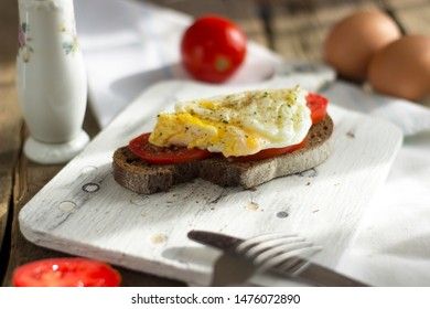 Poached egg on sourdough toast, with grilled tomatoes. A healthy, delicious breakfast or brunch.