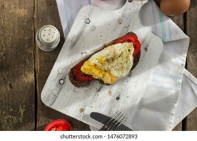Poached egg on sourdough toast, with grilled tomatoes. A healthy, delicious breakfast or brunch.