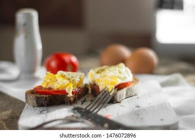 Poached egg on sourdough toast, with grilled tomatoes. A healthy, delicious breakfast or brunch.