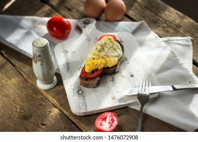 Poached egg on sourdough toast, with grilled tomatoes. A healthy, delicious breakfast or brunch.