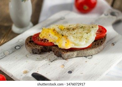Poached egg on sourdough toast, with grilled tomatoes. A healthy, delicious breakfast or brunch.