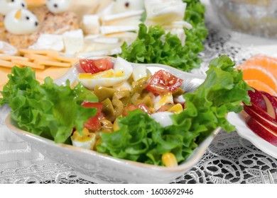 Greek salad with olives, tomatoes, feta cheese, onions in blue bowl on wooden background. Close up. Selective focus.