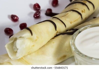 pancakes with cottage cheese, raisins and sour cream on a white plate