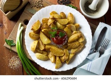 Country style fried potatoes with onions and ketchup. Fried potatoes in large slices.