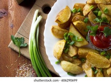 Country style fried potatoes with onions and ketchup. Fried potatoes in large slices.