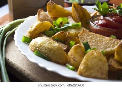 Country style fried potatoes with onions and ketchup. Fried potatoes in large slices.