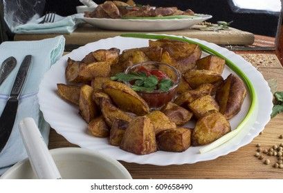 Country style fried potatoes with onions and ketchup. Fried potatoes in large slices.