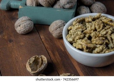 Peeled walnut in a white cup on a wooden background
