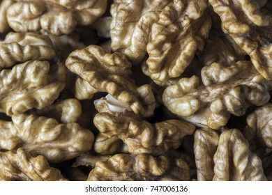 Peeled walnut in a white cup on a wooden background